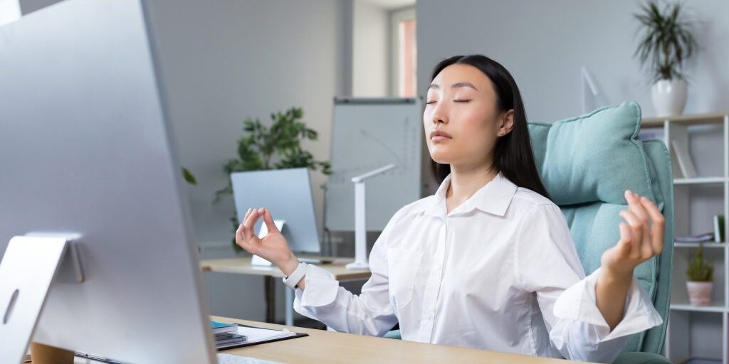 22-asian-business-woman-working-office-resting-meditating-doing-breathing-exercises-calm