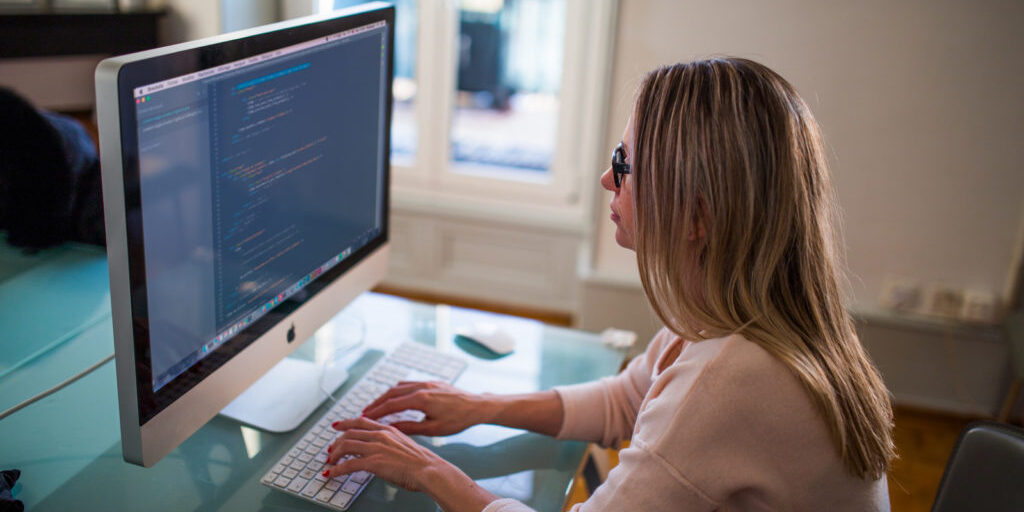 8-Canva-Seated-Woman-Typing-on-Apple-Mighty-Keyboard-in-Front-of-Turned-on-Silver-Imac-1-1024×683